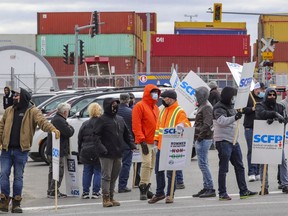 Longshoremen picket at the entrance to the Port of Montreal at Viau St. on the first morning of a strike in Montreal, April 26, 2021.
