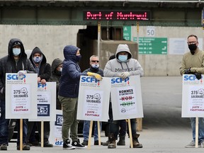 Striking dock workers block the entrance to the Port of Montreal along Pie-X Blvd. on April 26, 2021.