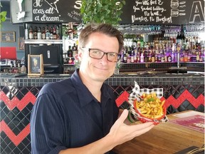 Dalhousie University researcher Sylvain Charlebois, known as "the food professor," enjoys a poutine at a restaurant in Brisbane, Australia.