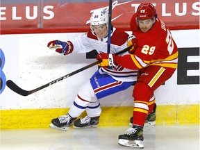 Canadiens' Cole Caufield battles Flames' Flames' Dillon Dubé during second-period action in Calgary on Monday. The game marked Caufield's NHL debut.