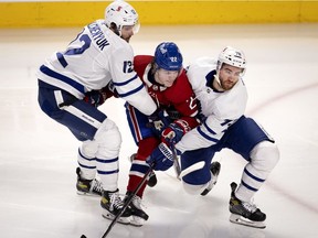 The Canadiens’ Cole Caufield is checked by the Toronto Maple Leafs' Alex Galchenyuk (left) and T.J. Brodie during game Wednesday night at the Bell Centre.