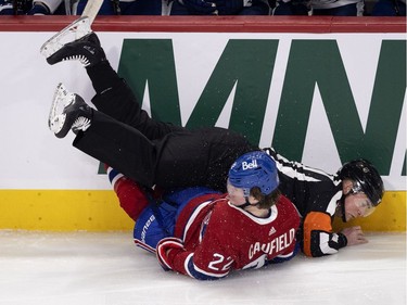 Habs right wing Cole Caufield collides with referee Marc Joannette during first-period action in Montreal on Wednesday, April 28, 2021.