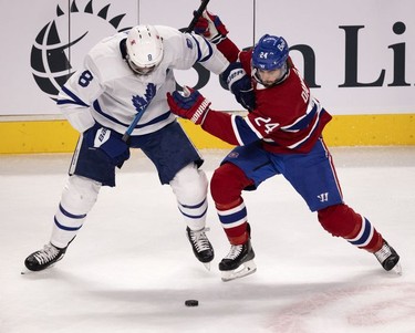 Toronto Maple Leafs defenseman Jake Muzzin tries to hold off Habs left wing Phillip Danault during first-period action in Montreal on Wednesday, April 28, 2021.