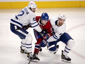 Toronto Maple Leafs centre Alex Galchenyuk, left, and defenseman T.J. Brodie take out Habs right wing Cole Caufield as he drives for the net during first-period action in Montreal on Wednesday, April 28, 2021.