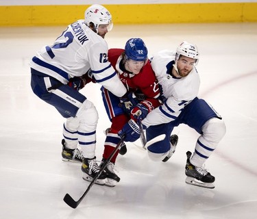 Toronto Maple Leafs centre Alex Galchenyuk, left, and Toronto Maple Leafs defenseman T.J. Brodie take out Habs right wing Cole Caufield as he drives for the net during first-period action in Montreal on Wednesday, April 28, 2021.