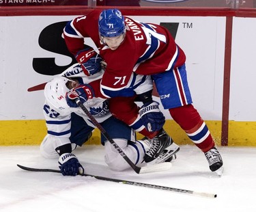 Habs centre Jake Evans drives Toronto Maple Leafs defenseman Travis Dermott to the ice after taking a big check from Dermott during third-period action in Montreal on Wednesday, April 28, 2021.