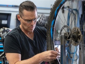 With business slow in his day job in the airline business, Raymond Oesterreich made the pivot into bicycle sales and service where business is booming. Oesterreich trues a wheel at the Giant store in Vaudreuil on Wednesday April 28, 2021.
