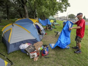 A homeless man folds a tarp outside his tent at an encampment along Notre-Dame St. East on August 9, 2020. Greater availability of rent supplements could avoid a repeat this summer, James Hughes suggests.