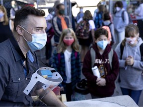 Music teacher Francois Lukawecki chats with students as they wait to enter for the first day of classes at Bancroft Elementary School last August. All teachers deserve respect, recognition and support for their tremendous efforts, Allison Hanes writes.