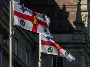 The Montreal flags at city hall, which Mayor Valérie Plante says will be lowered to honour the 215 children whose remains were found at the site of a residential school in B.C.