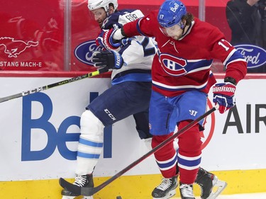 Josh Anderson holds off Winnipeg Jets' Derek Forbort as he tries to control the puck during first-period action at the Bell Centre in Montreal on Thursday, April 8, 2021.
