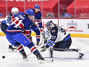 Connor Hellebuyck of the Winnipeg Jets tends goal near Canadiens' Jake Evans during the second period at the Bell Centre on Saturday, April 10, 2021, in Montreal.