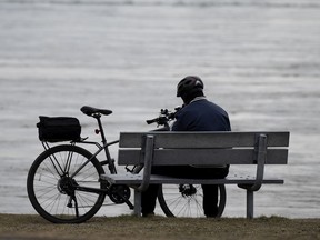 A man enjoys a quiet moment alone along the shore of Lac St. Louis in Montreal on Wednesday, April 7, 2021.