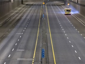 An ambulance heads south on the Décarie Expressway as an 8 p.m. curfew begins in Montreal on Sunday, April 11, 2021.