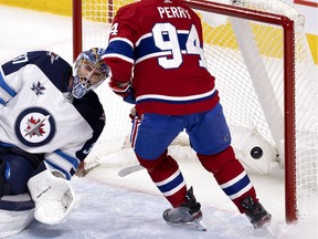 Montreal Canadiens right wing Corey Perry (94) skates behind Winnipeg Jets goaltender Connor Hellebuyck (37) as the Montreal Canadiens score during NHL action in Montreal on Friday, April 30, 2021.