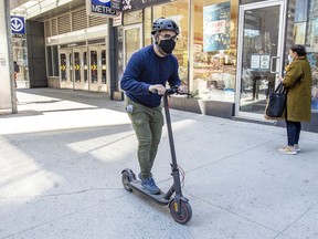 A mask-wearing man rides a scooter after exiting the Guy-Concordia Metro on Guy St. during continuing pandemic in Montreal Wednesday April 7, 2021.