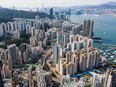 An aerial view shows residential and commercial buildings on Hong Kong island (foreground and L) and Kowloon (top R), either side of Victoria Harbour, on February 17, 2020.