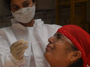 A medical staff takes a nasal swab for a Rapid Antigen Testing (RAT) test amidst rising COVID-19 cases, in Mumbai on April 19, 2021.