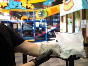 A police officer handles two bags of drugs at the Karebear Playland facility in Brampton.