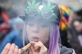 FILE: A woman smokes marijuana on Parliament Hill on 4/20 in Ottawa, Ontario, Apr. 20, 2017. /