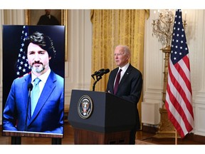 Prime Minister Justin Trudeau appears on- screen as U.S. President Joe Biden speaks to the media in February after the two held a virtual bilateral meeting. The Americans have hit their stride in battling COVID-19; Canada's approach lacks focus and coherence.