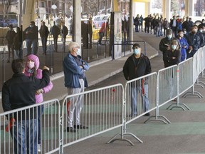 People wait in line at a COVID-19 vaccination clinic to receive the AstraZeneca vaccine at Olympic Stadium in Montreal, on Thursday, April 8, 2021.