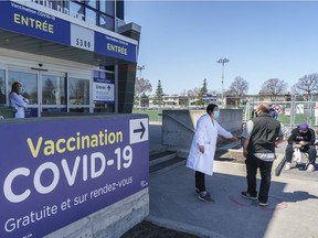 CP-Web. A man is greeted at a COVID-19 vaccination clinic at the Martin Brodeur Arena in Montreal, on Tuesday, April 13, 2021.