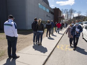 People line up at a COVID-19 vaccination centre in Deux-Montagnes on Friday. "It's a race against time. We have to vaccinate the most people possible so they can't transmit the disease," said Michel Roger, medical director of Quebec’s public health laboratory.