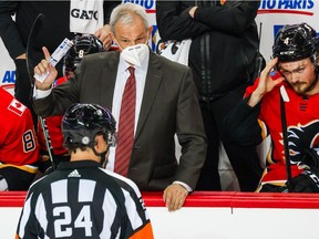 Calgary Flames head coach Darryl Sutter talks to referee Graham Skiliter (24) during the second period against the Montreal Canadiens in Calgary.