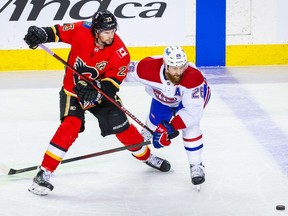 Flames' Sean Monahan (23) and Canadiens defenceman Jeff Petry  battle for the puck during the first period at Scotiabank Saddledome in Calgary on Saturday, April 24, 2021.