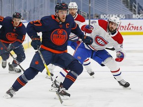 Oilers forward Connor McDavid tries to skate away from the Canadiens’ Phillip Danault during Monday night’s game in Edmonton.