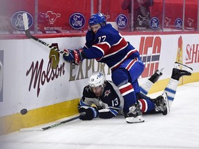 Winnipeg Jets forward Pierre-Luc Dubois (13) and Canadiens defenceman Brett Kulak (77) battle for the puck during the first period at the Bell Centre on Saturday, April 10, 2021, in Montreal.