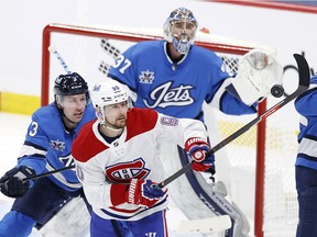 Montreal Canadiens left wing Tomas Tatar (90) tries to knock down the puck in front of Winnipeg Jets defenceman Tucker Poolman (3) in Winnipeg March 17, 2021.