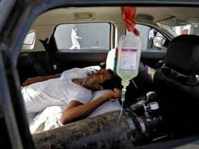 A patient with breathing problems lies inside a car while waiting to enter a COVID-19 hospital for treatment, amidst the spread of the coronavirus disease (COVID-19), in Ahmedabad, India, April 22, 2021.