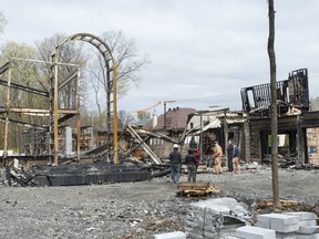 Investigators examine the scene of a fire that destroyed a $19.5 million mansion under construction for Mindgeek, which is the parent company of the Pornhub website, executive  Feras Antoon Monday, April 26, 2021 in Montreal.THE CANADIAN PRESS/Ryan Remiorz ORG XMIT: RYR101-04-26