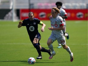 Toronto FC forward Jacob Shaffelburg and CF Montreal midfielder Samuel Piette, left, battle for the ball during the second half at DRV PNK Stadium in Fort Lauderdale, Fla., on April 17, 2021.