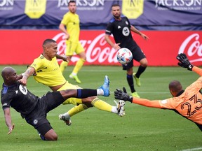 Nashville SC forward Jhonder Cadiz (99) shoots the ball over CF Montréal goalkeeper Clement Diop (23) as he is defended by CFM defender Kamal Miller (3) during the first half  at Nissan Stadium in Nashville, Tenn., on Saturday, April 24, 2021.