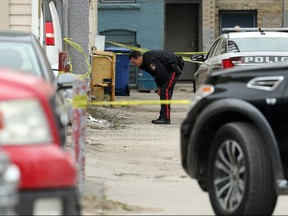 A police officer investigates at the scene of a shooting in Winnipeg on Sept. 12, 2019.