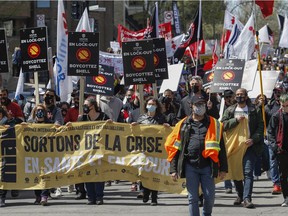 People take part in the May Day march in Montreal Saturday, May 1, 2021. Members of the Montreal dock workers union were part of the march.