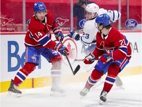 Montreal Canadiens' Nick Suzuki, left, and Cole Caulfield in action against Toronto Maple Leafs' Travis Dermott during third period in Montreal on May 3, 2021.