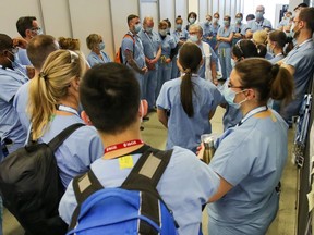 Vaccinators gather for their daily briefing prior to their afternoon shift at the COVID-19 vaccination clinic at the Palais des congrés in Montreal on Tuesday, May 4, 2021.