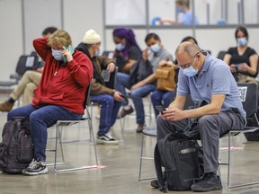 People sit in the post-vaccination waiting area at the COVID-19 vaccination clinic at the Palais des congrés in Montreal Tuesday May 4, 2021.