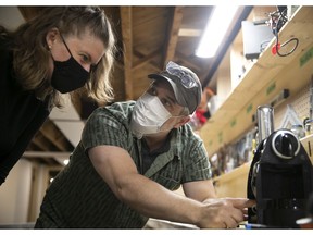 Jean-Philippe Roy helps Krystel Papineau on trying to figure out how to fix her broken cappuccino machine at the community organization Mon Atelier on Tuesday May 4, 2021 during the COVID-19 pandemic.