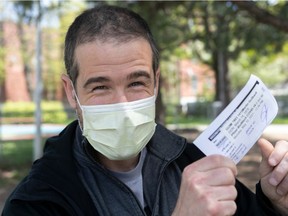 Martin Guilbault shows his vaccination paper on Monday.