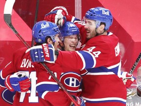 Artturi Lehkonen is congratulate by team-mates Jake Evans, left, and Joel Edmundson after scoring goal to tie the game during third-period action in Montreal on Monday, May 10, 2021.