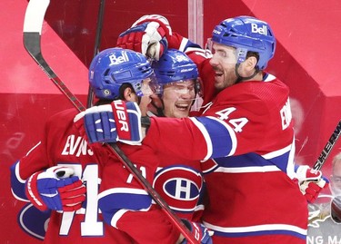 Artturi Lehkonen is congratulate by team-mates Jake Evans, left, and Joel Edmundson after scoring goal to tie the game during third-period action in Montreal on Monday, May 10, 2021.