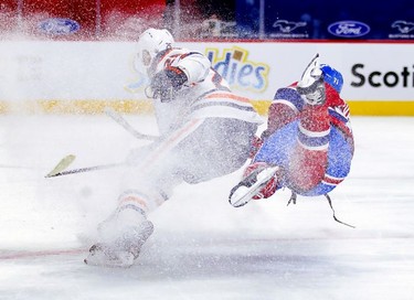 Jake Evans, right, shoots the puck while falling to the ice in a snow shower behind Edmonton Oilers' Darnell Nurse for the Habs goal during first- period action in Montreal on Monday, May 10, 2021.