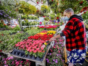 Ashley Jones waters flowers at Angel Jardins in Atwater Market on May 11, 2021.