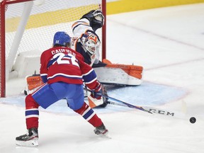 Cole Caufield has the puck poked away from him by Edmonton Oilers goalie Mike Smith during third-period action in Montreal on Wednesday, May 12, 2021.