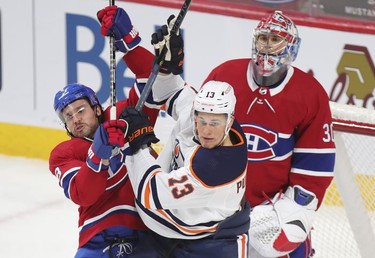 Ben Chiarot, left, jostles with Edmonton Oilers' Jesse Puljujarvi in front of Habs goalie Cayden Primeau during third-period action in Montreal on Wednesday, May 12, 2021.